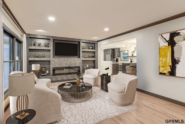 living room featuring baseboards, light wood-style flooring, crown molding, built in shelves, and a high end fireplace