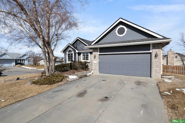 single story home with brick siding, driveway, and fence