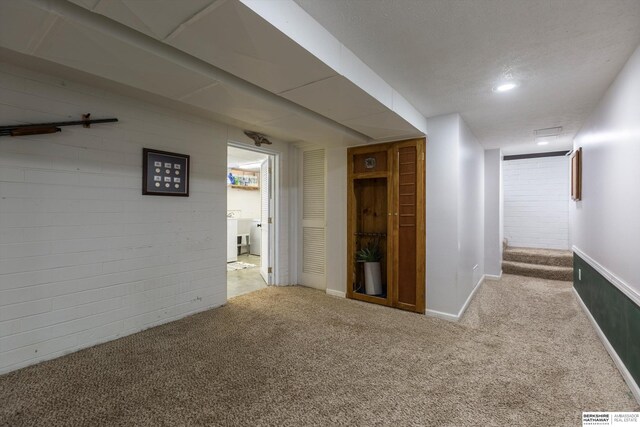 hallway featuring light carpet and baseboards
