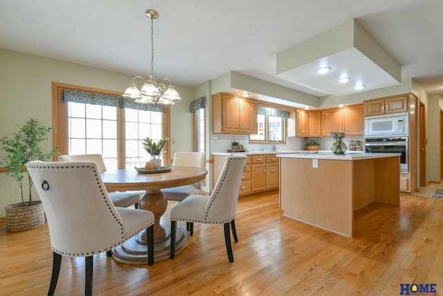 dining area featuring an inviting chandelier and light wood-style flooring