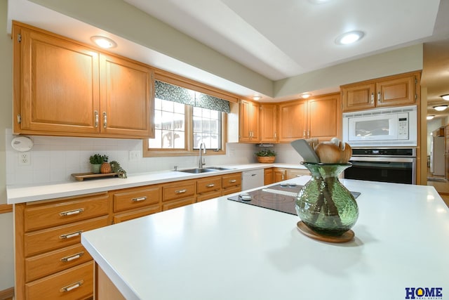 kitchen with light countertops, decorative backsplash, recessed lighting, white appliances, and a sink