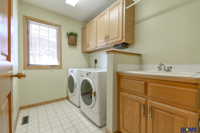 laundry area with visible vents, washing machine and dryer, light floors, cabinet space, and a sink