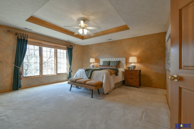 bedroom featuring visible vents, light carpet, a raised ceiling, a ceiling fan, and baseboards