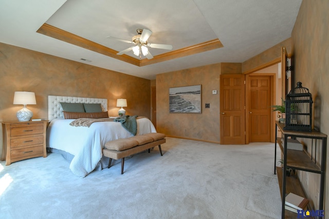 bedroom featuring visible vents, baseboards, a tray ceiling, ceiling fan, and carpet flooring