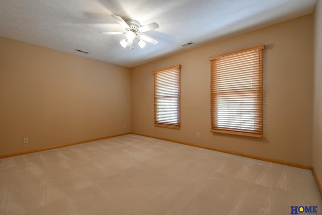 unfurnished room featuring visible vents, baseboards, carpet, and a ceiling fan