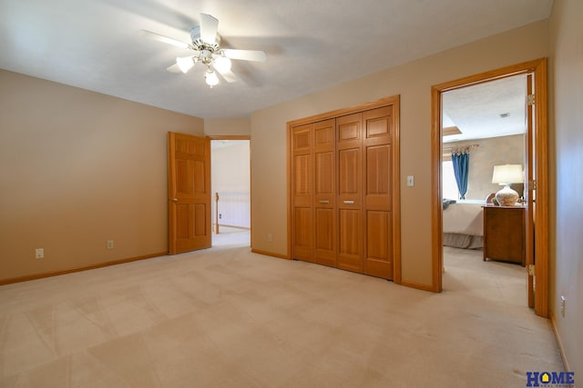 unfurnished bedroom with light colored carpet, a closet, and baseboards