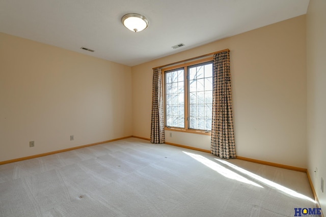 spare room with visible vents, baseboards, and light colored carpet