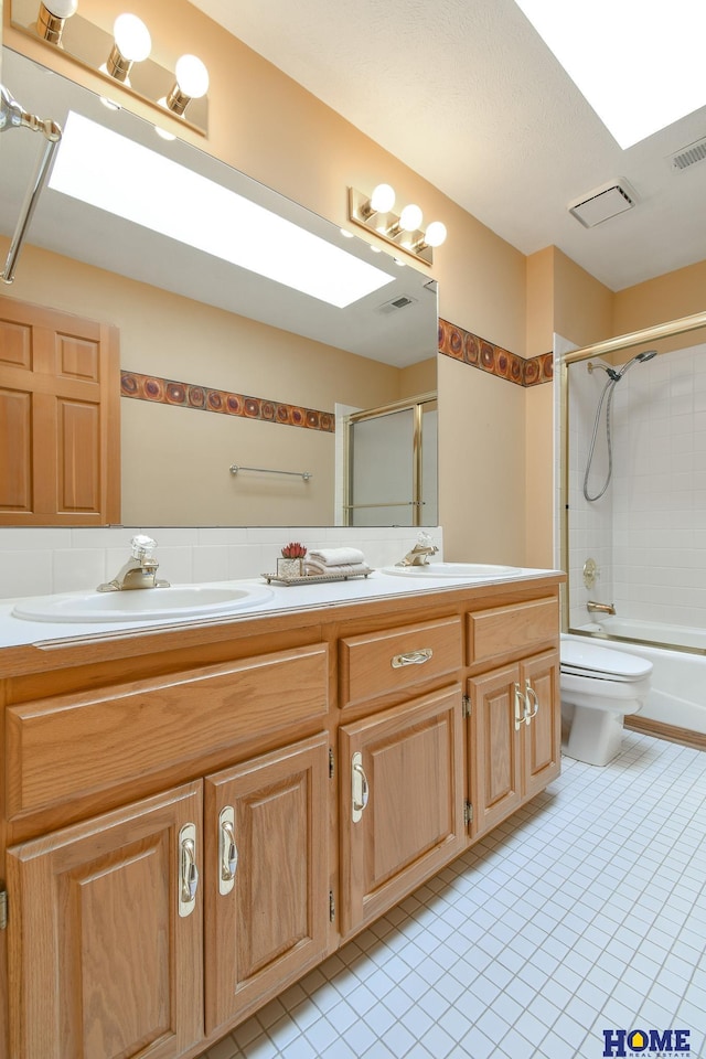 bathroom with double vanity, toilet, visible vents, and a sink