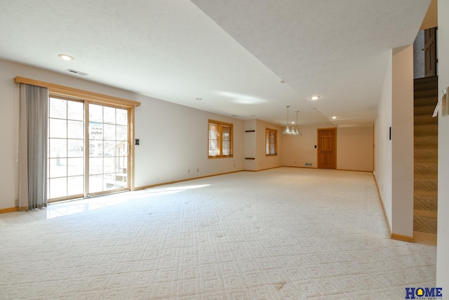 interior space featuring stairs, light colored carpet, visible vents, and baseboards