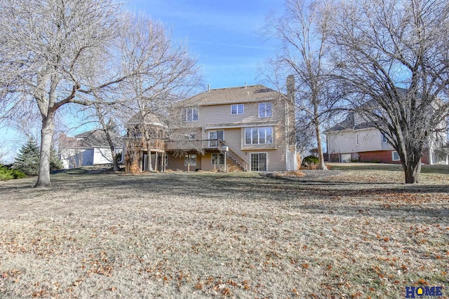 back of house featuring stairway, a yard, a wooden deck, and a chimney