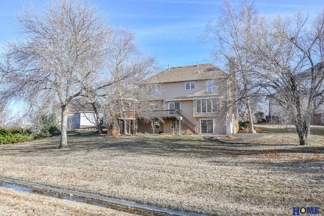 view of front of house featuring a front lawn, a deck, and stairs