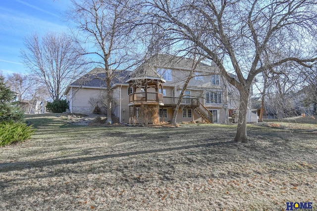 view of front of home featuring stairway, a front yard, and a deck