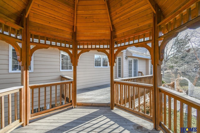 wooden deck with a gazebo and an outbuilding