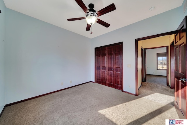 unfurnished bedroom featuring baseboards, carpet floors, a closet, and a ceiling fan