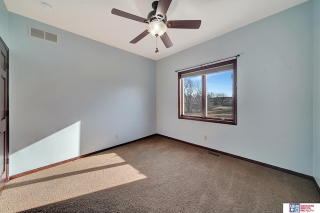 carpeted spare room featuring visible vents, baseboards, and ceiling fan