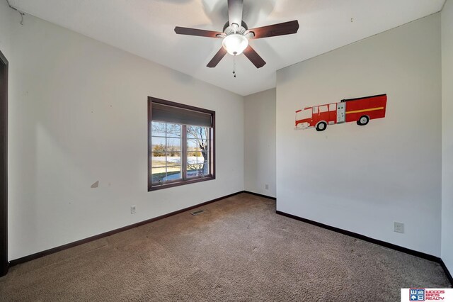 spare room featuring baseboards, carpet floors, and ceiling fan