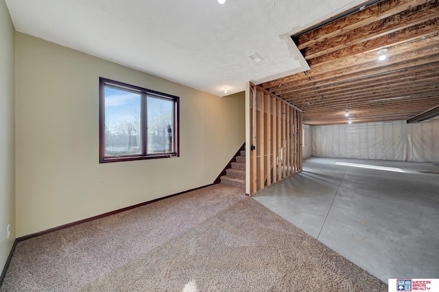 basement featuring stairway and baseboards