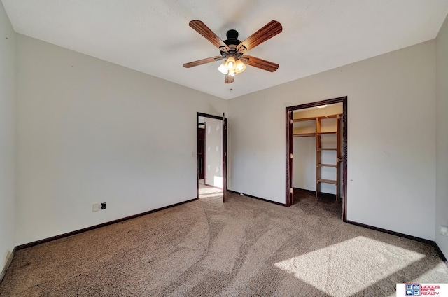 unfurnished bedroom featuring a walk in closet, a ceiling fan, a closet, carpet flooring, and baseboards