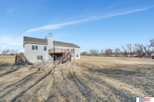 back of property with a deck, stairway, a lawn, and a chimney