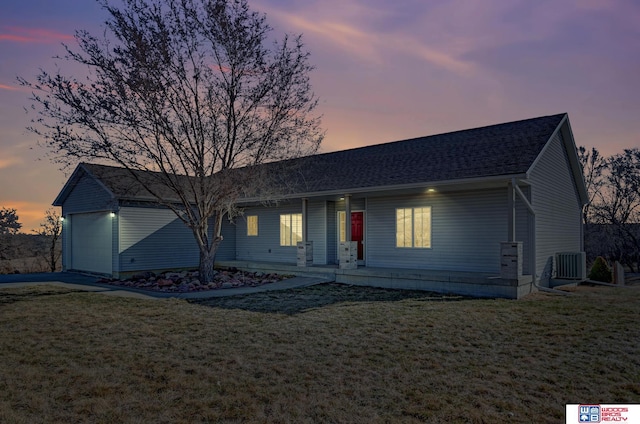 ranch-style house with central AC unit, an attached garage, and a front yard