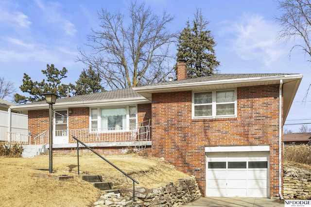 view of front of home with concrete driveway, brick siding, a chimney, and an attached garage