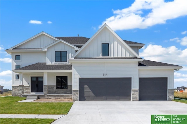 view of front of house with roof with shingles, concrete driveway, board and batten siding, a garage, and stone siding