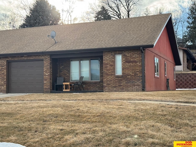 view of front of property with brick siding, an attached garage, and a front yard