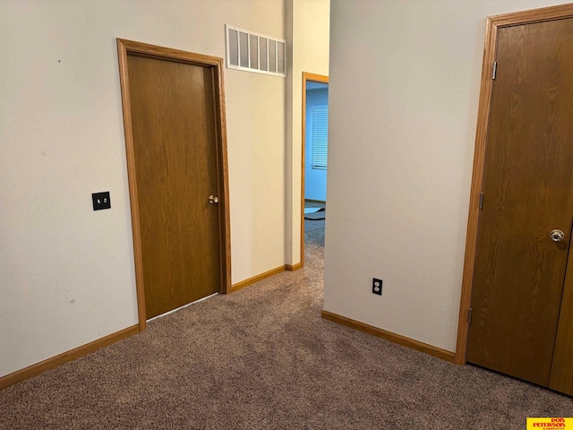 unfurnished bedroom featuring carpet floors, baseboards, and visible vents