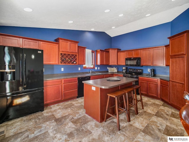kitchen with a breakfast bar, a sink, high vaulted ceiling, a center island, and black appliances