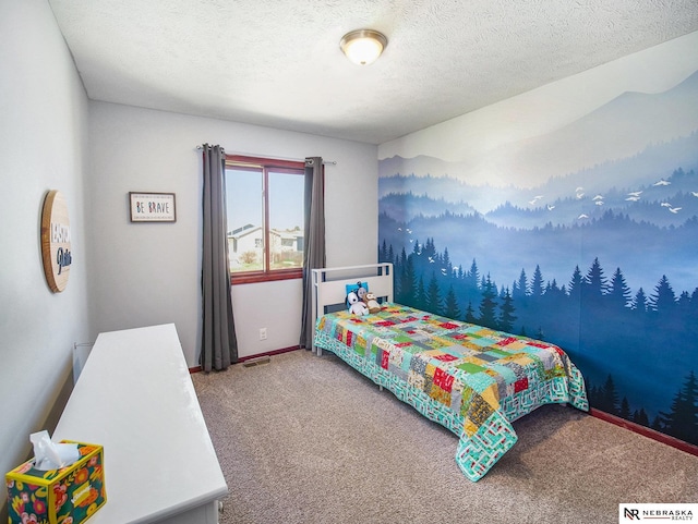 bedroom with baseboards, carpet flooring, and a textured ceiling