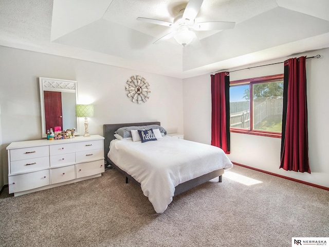 bedroom featuring light colored carpet, a ceiling fan, and a textured ceiling