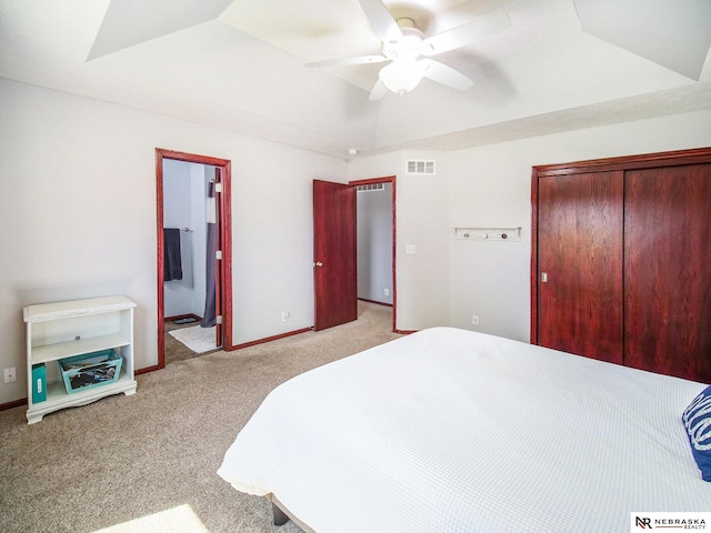 carpeted bedroom featuring ceiling fan, visible vents, baseboards, a closet, and ensuite bathroom