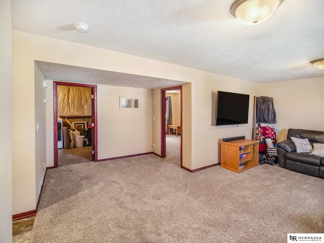 carpeted living area featuring a textured ceiling and baseboards