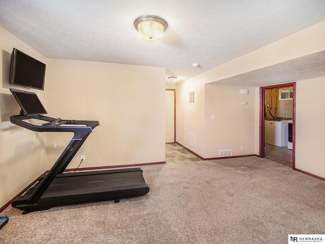 exercise area with carpet floors, a textured ceiling, visible vents, and baseboards