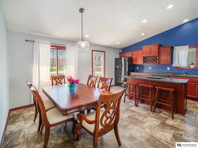 dining area with a textured ceiling, recessed lighting, baseboards, stone finish flooring, and vaulted ceiling