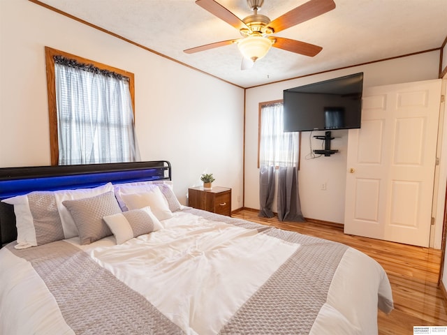 bedroom featuring ornamental molding, ceiling fan, a textured ceiling, and light wood finished floors