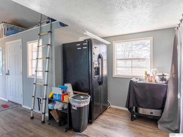 miscellaneous room with a textured ceiling, wood finished floors, and baseboards