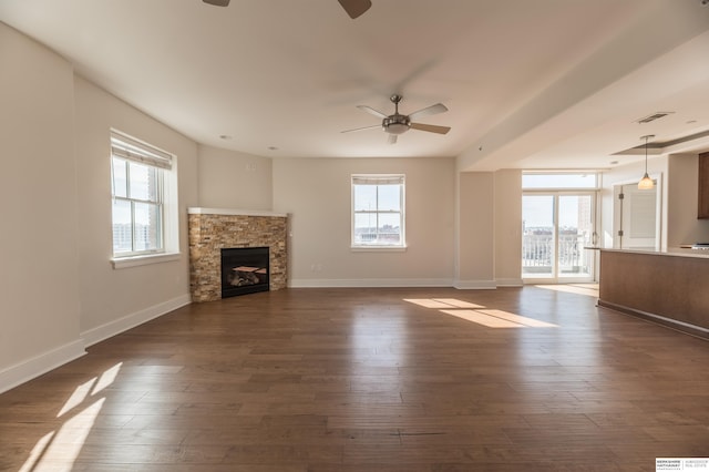 unfurnished living room featuring plenty of natural light and dark wood-type flooring