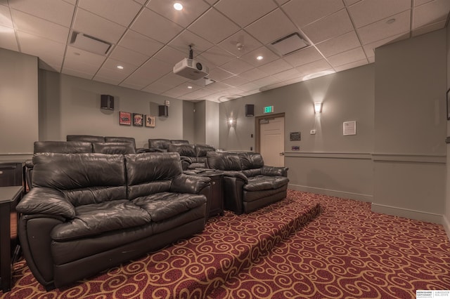 carpeted cinema with baseboards, visible vents, and a drop ceiling