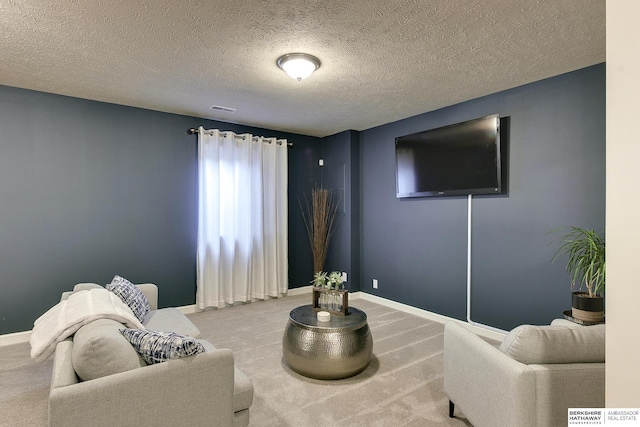 sitting room featuring carpet floors, visible vents, a textured ceiling, and baseboards