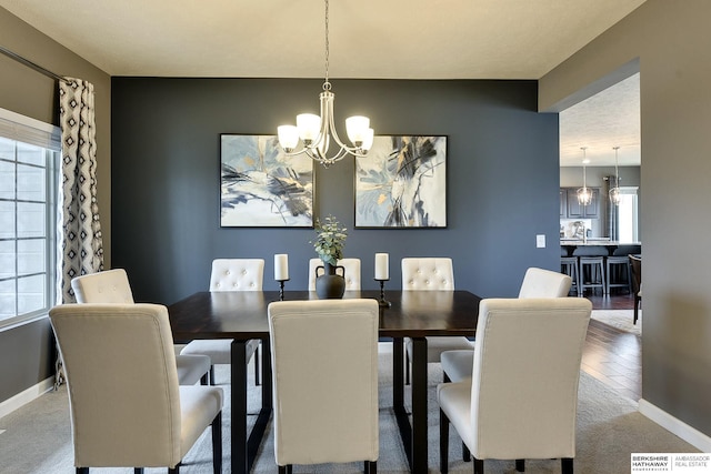 dining space with baseboards, visible vents, and a notable chandelier