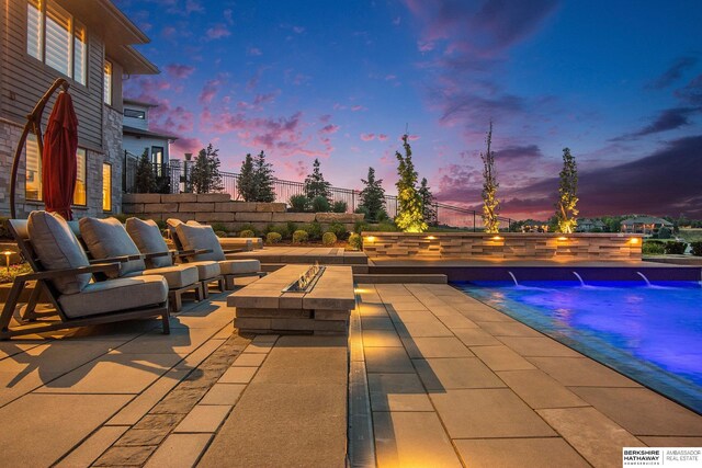 view of patio / terrace featuring an outdoor pool and a fire pit