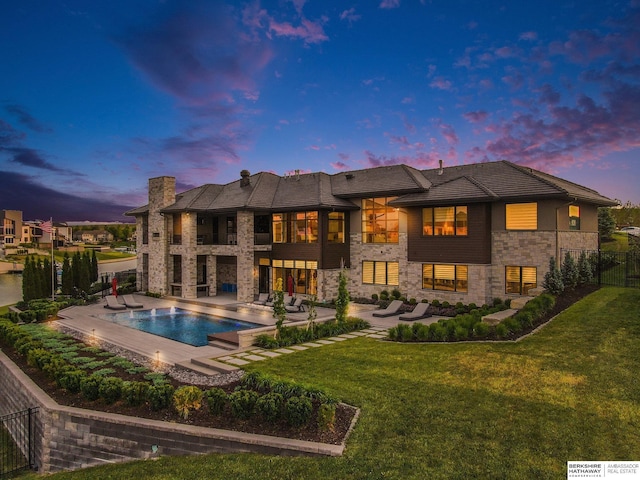 rear view of house featuring a fenced in pool, a patio area, a yard, and fence