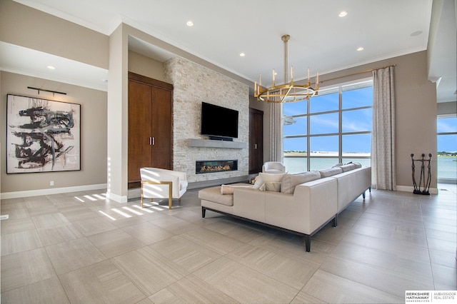 living room with ornamental molding, a fireplace, an inviting chandelier, and baseboards