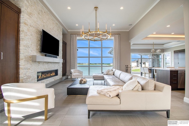 living area featuring an inviting chandelier, crown molding, and a stone fireplace