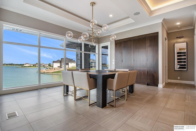 dining space with a chandelier, a water view, visible vents, baseboards, and a tray ceiling