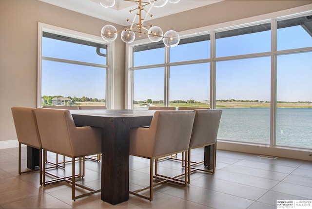 dining area with a water view, an inviting chandelier, baseboards, and visible vents