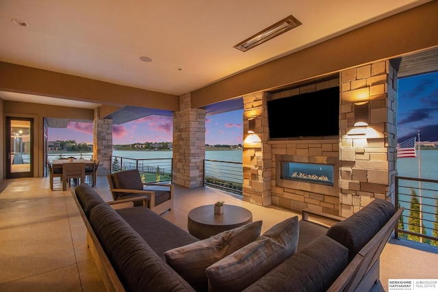 living room with an outdoor stone fireplace and ornate columns