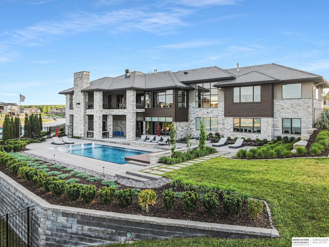 rear view of property featuring a patio, fence, a yard, a fenced in pool, and a chimney