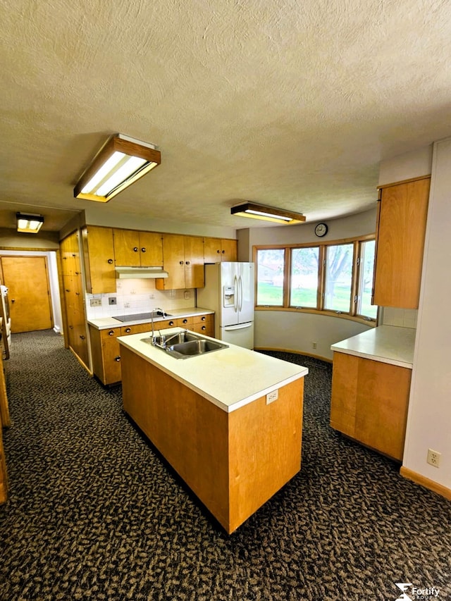 504 N Plum St, Shickley, NE 68436 - kitchen with white fridge with ice dispenser, a sink, a textured ceiling, brown cabinets, and under cabinet range hood